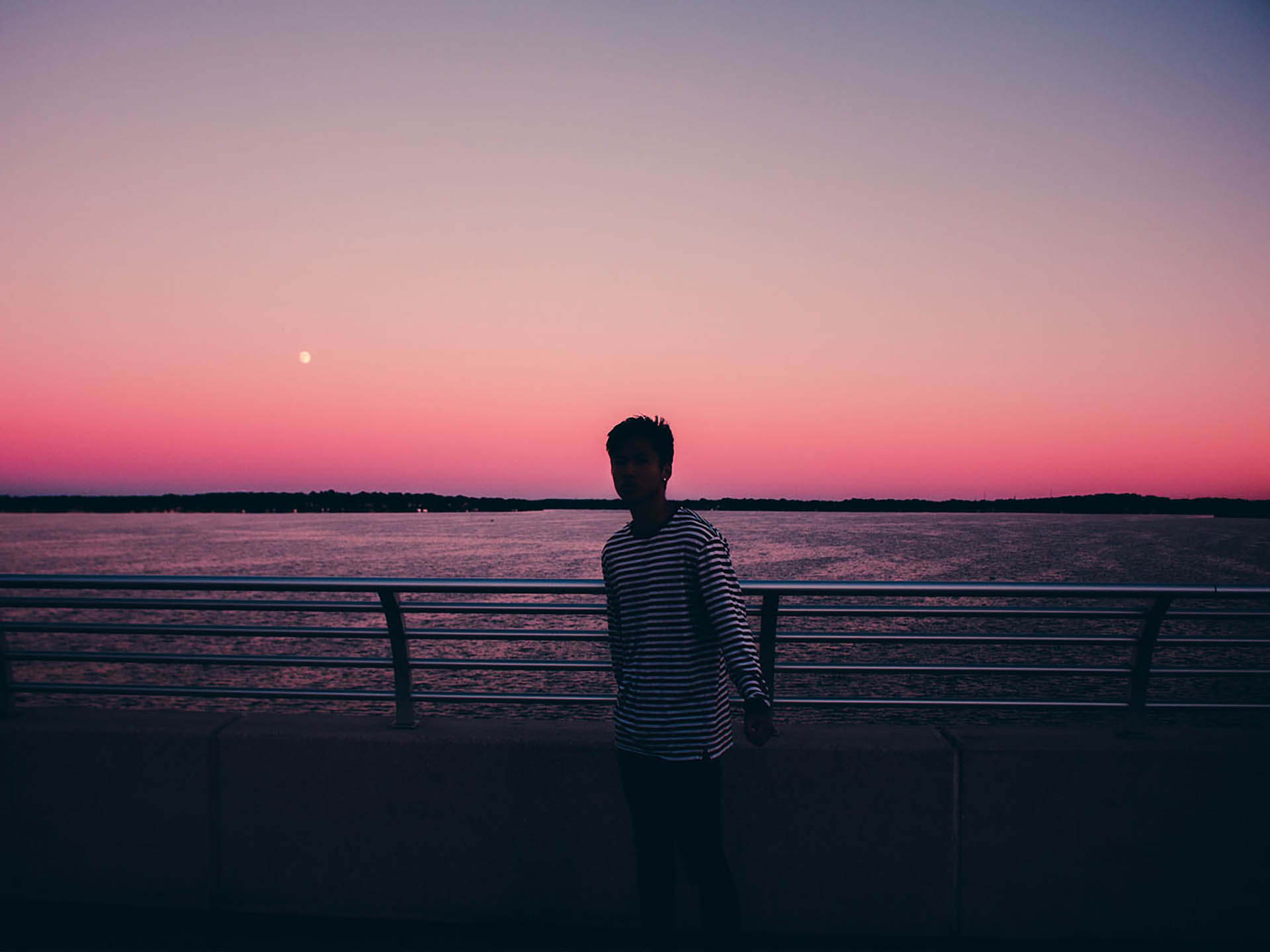 Semi-silhouette boy standing in front of the moonlit sky