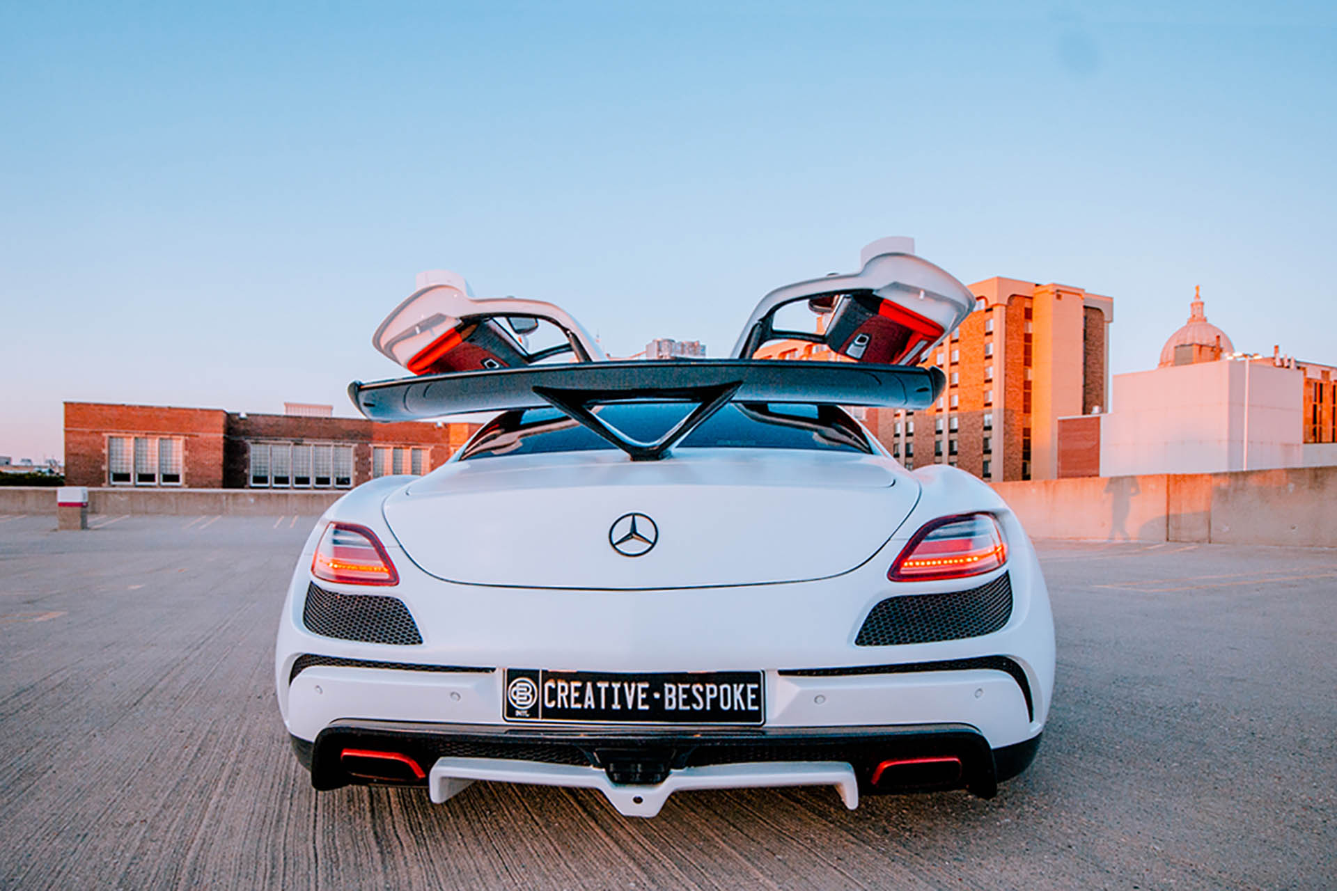 White Mercedes Benz with a creative license plate.