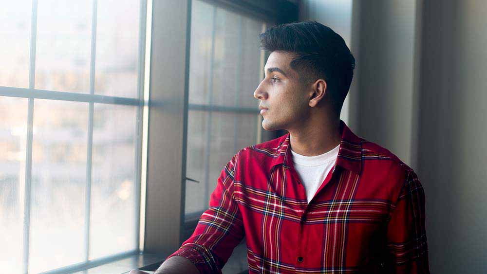 Man staring outside of window