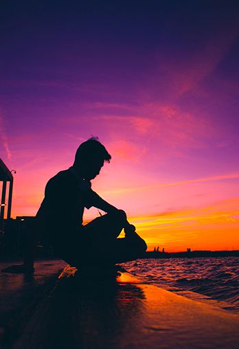 Person Kneeling infront of Sunset