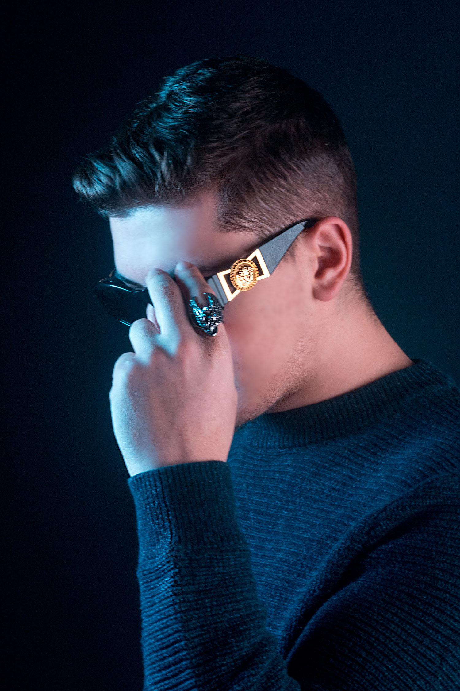 Male model holding Verscace sunglasses in photography studio, Milwaukee Wisconsin, Northern Lights